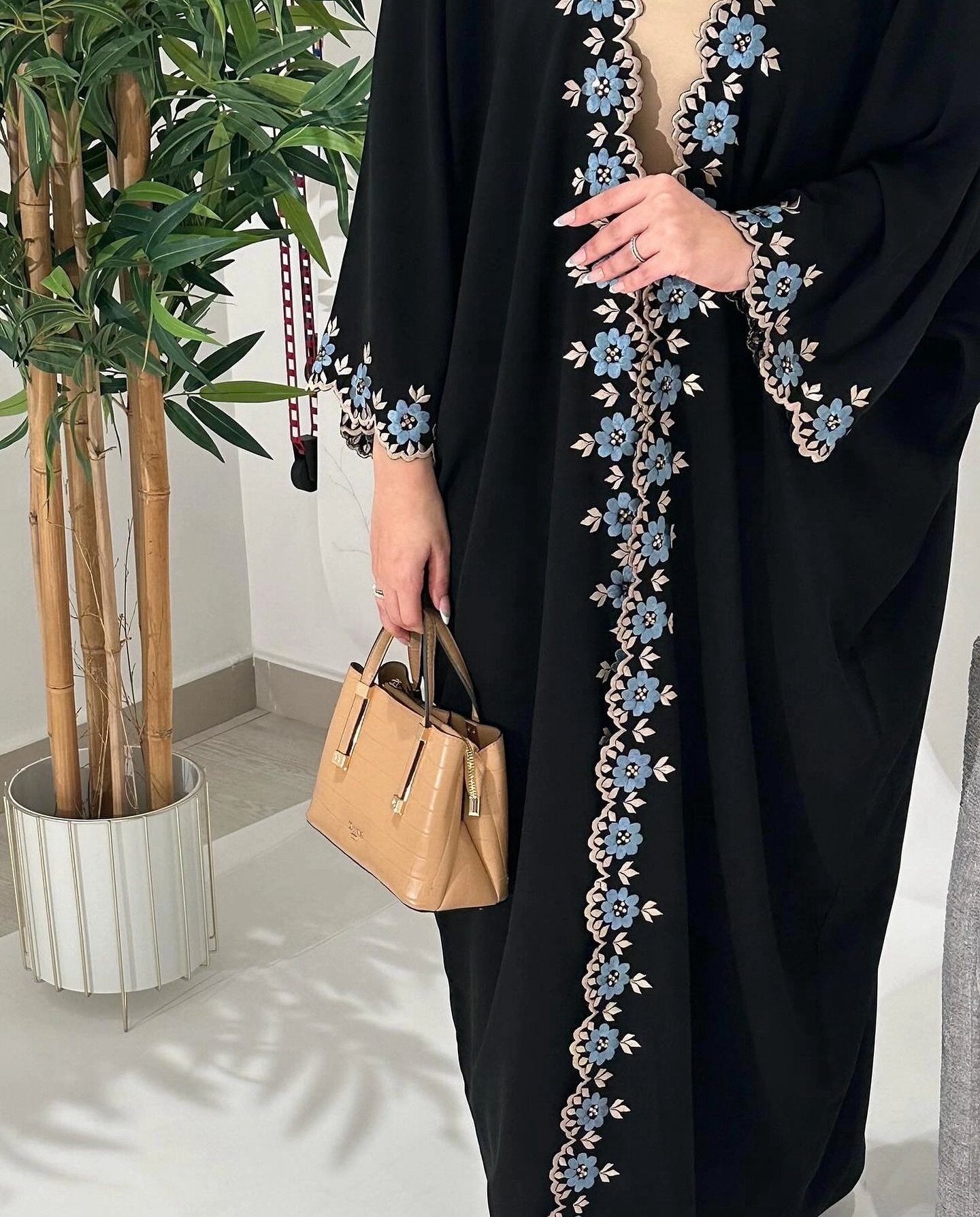 عباية سوداء بتطريز زهور زرقاء